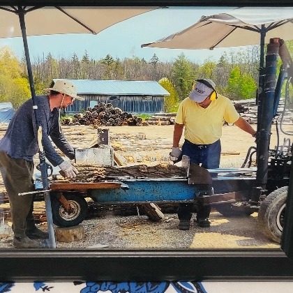 two men loading wood onto a flat trailer